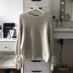 Stickad tröja - Beige superfin stickad tröja från chiquelle. Tröjan har vida ärmar med rosetter som man knyter själv och även slits i sidorna. Tröjan passar fler storlekar då den är i onesize (jag bär vanligtvis storlek S).
