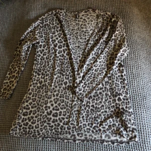 Kofta i leopardmönster - Grå kofta med leopardmönster. Koftan faller väldigt fint. 