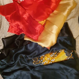 Satin rockar - Mycket fina, handsydda. Använd 1 gång. Den grön/svart för herr.Nypris 499kr.Säljs för 200kr. Används båda sidor.  Den röda, gula för dam.Nypris 299kr st. Säljs för 200kr 2 st.