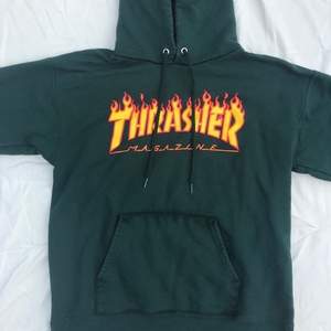 Skogsgrön thrasher hoodie med eld text. Frakt ingår ej