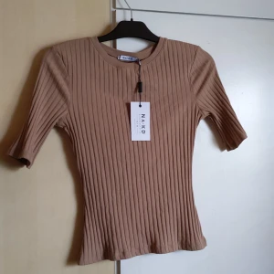 Beige ribbad tröja från nakd - Tröjan e bara provad, inte använd! Taggen sitter fortfarande kvar. Det står L men känns mer som en M 