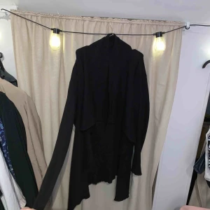  - Svart ribbad kofta i tyngre tyg som faller fint. Längre när den sitter på.  Betalas med swish. Kan mötas upp i Halmstad eller skicka mot frakt som betalas av köparen. 