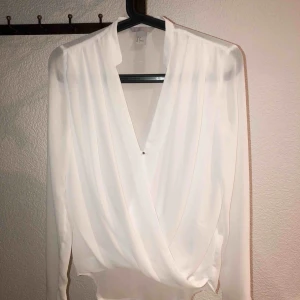  - Vit blus från H&M i bra sick. Dubbelt lager framtill, lite genomskinlig bak. 