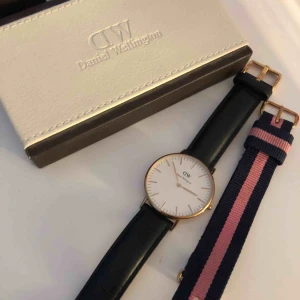  - Äkta Daniel Wellington klocka i roseguld med svart läderarmband och ett tillhörande rosa med blåränder. Sparsamt använd.