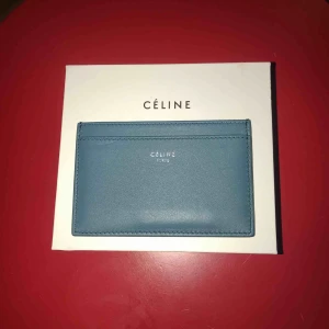  - Céline plånbok / korthållare i blå och svart. Aldrig använd. Dustbag, box, tag och äkthetscertifikat finns med. Inhandlad på Nathalie Schuterman i Stockholm för ca 1 1/2 år sedan.  Nypris ca $360. Köparen står för frakten. Kan mötas upp i centrala Sthlm! 