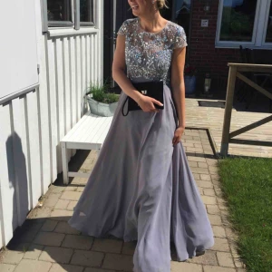 - Säljer min fina grå balklänning med broderade pärlor. Passar en XS/S/M, beror på kroppstyp, men finns en dragkedja bak. Jag är 173 cm. Bara använd en gång så i bra skick. Kemtvättad! Nypris 4990. Byst: ca 75-80 cm  Midja: ca 62-67 cm