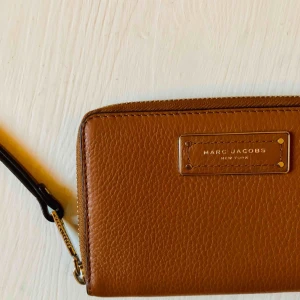  - Ljusbrun wristlet plånbok från Marc Jacobs.  iPhone 8 får plats i mobil facket. Använd 2 gånger. 