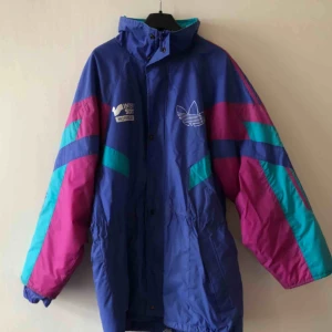  - Vintage adidas lång täckjacka med Intersport tryck på bröst och rygg. Lagat med patchar på ryggen. Se bild. 80/90-tal 