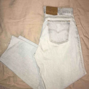  - Levi’s vintage jeans i modellen ”550”. Ljusblå/blekta i färgen och avklippta vid anklarna. Strl. 32 men kan bäras som oversized modell! Ett mindre, ihopsytt hål på knät samt en liten fläck under.  Upphämtas i Göteborg/köparen för frakten! 