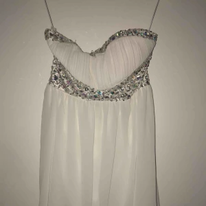  - vit klänning med paljetter, vadderingen i byster är borttagen på grund av att den syntes igenom tyget när man hade klänningen på sig, några pärlor fattas. Storlek L. Frakt tillkommer!