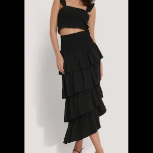 Lång kjol med volanger  - Lång kjol med volanger från nakd. Helt oanvänd med taggar kvar. Storlek 34. Ordinarepris 399kr. Mitt pris 270kr. Ink gratis frakt !