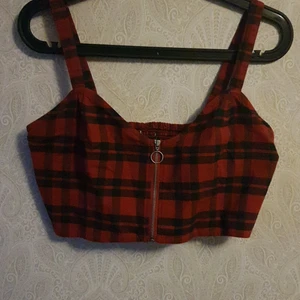 Röd/grön rutig topp - söt top som köptes secondhand men är i bra skick. banden är justerbara och den är lite strechig i bak. säljes för 90kr plus frakt elr upphämtning i kalmar. 
