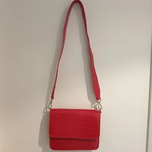 Axelväska - Säljer en superfin röd axelväska från Ginatrico. Stängs med magnet och det breda axelbandet är löstagbart. Köpt för ett år sedan men skicket är som nytt. Kan mötas i Stockholm eller frakta för 60 kr. Det är bara att skriva om du har några frågor😊