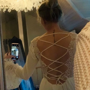 Vit klänning i spets XS - Vit spetsklänning säljes då den inte kommit till användning. Fin snörning i ryggen, djup rygg.  Köpt på DM, Dennis Maglic. Storlek XS. 