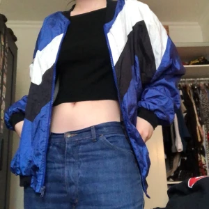 Windbreaker - Jacka i prasslig material, bra skick. Passar nog allt mellan XS till L. Har katt så det kan finnas katthår. Möts enbart