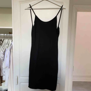  - Svart oanvänd klänning med öppen rygg