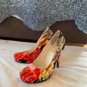  - Blommiga pumps i nyskick.  Storlek 37.   Finns att hämta en mil från Umeå, kan tas med till centrum.  Eller skickas mot fraktkostnad. 