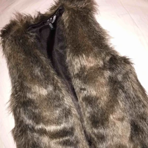  - Fluffig, varm och jättemysig fuskpälsväst. Använd ENDAST två gånger, är i toppskick.  Kan mötas upp i Stockholm City eller skicka med Postnord. Swish-betalning.