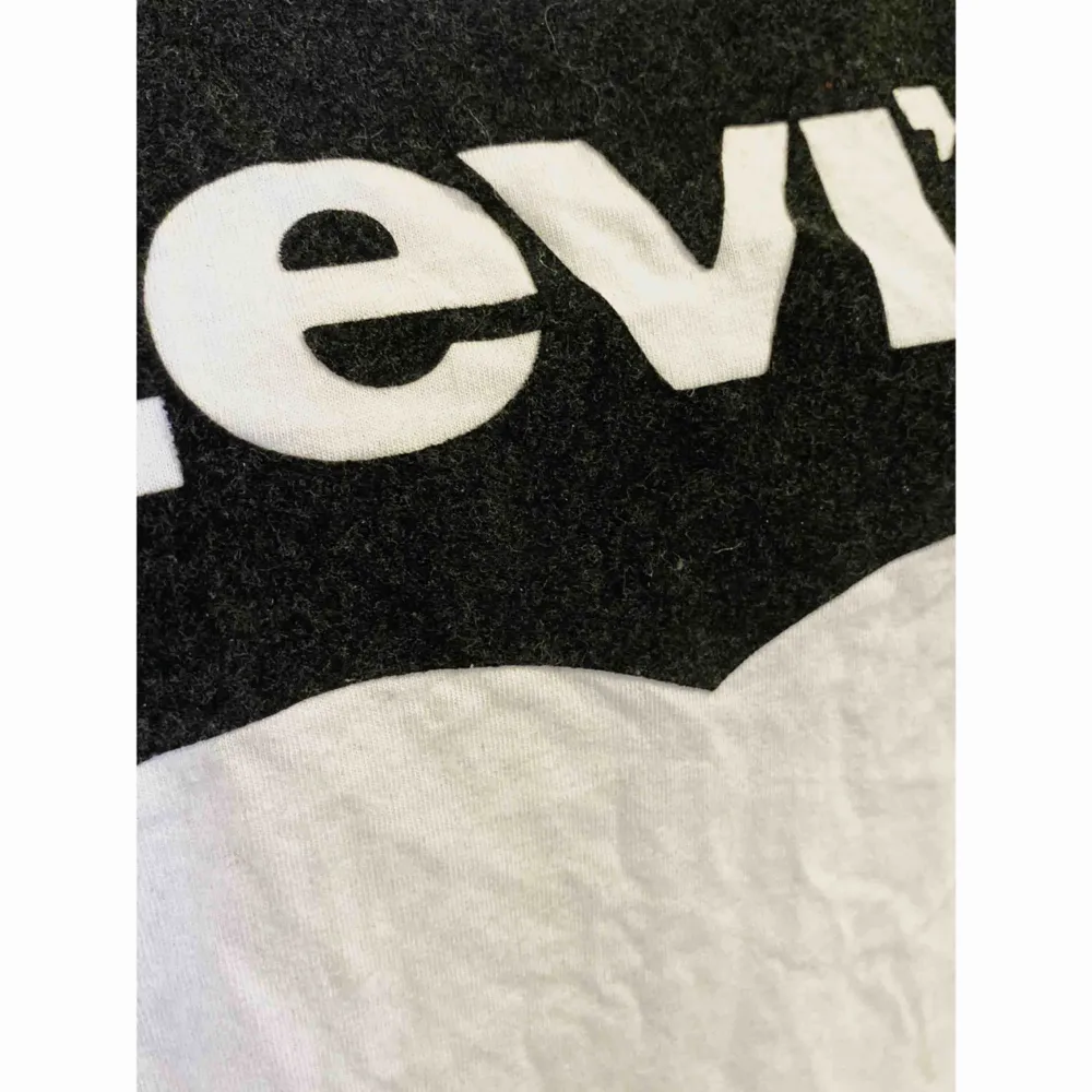 Vit t-shirt med svart tryck från Levis. Trycket är som mjukt. Den är i storlek S, oanvänd. . T-shirts.