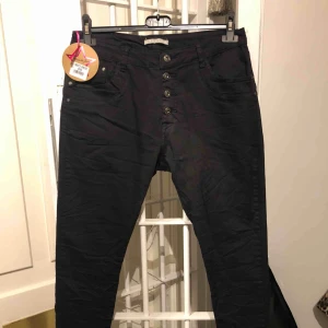  - Svarta stretchbyxor i märket Palce de jour. Knappar som gylf. Aldrig använda.  Storlek 40.