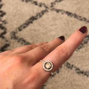  - Säljer min jätte fina Lily and Rose ring! Det är en ljus rosa sten i mitten och så är det silver stenar runt om. Använd få tal gånger och det är i väldigt bra skick. Köparen står för frakten! 💗