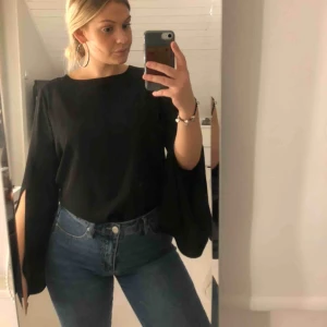  - Svart calvin klein blus med slits i ärmarna.