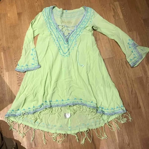  - Underbar strandklänning från Fo Lou. Fransar nedtill och längre bak än fram. Limegrön med turkosa broderier. 