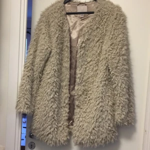  - Fuskpälsjacka som är perfekt nu på våren!
Aldrig använd. Har oftast medium, sitter som en s/m. Två sidofickor och knäpps med "hakar". 
Finns i Göteborg. Kan mötas upp, eller skicka mot fraktkostnad. 
