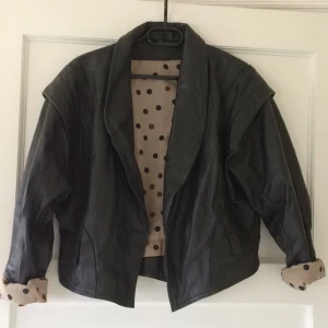  - Cool retro skinnjacka med prickigt foder! Det saknas en knapp och det är ett litet hål på fodret vid varje axel för att jag tagit ut axelvaddar. Det är dock ingenting som märks och väldigt lätt att fixa till om en vill det.  Kan mötas upp i Uppsala, annars står köparen för frakten:) 