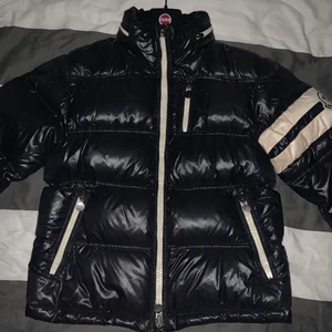 Moncler jacka stl 3 - Fin vintage moncler jacka, från 2007. Säljer den pågrund av att jag har växt ur den! Jackan är i väldigt bra skick och har bara några mindre skönhetsfel. Den har en repa bredvid bröstfickan som man kan se på den tredje bilden! Nypris 10500kr 