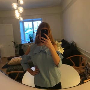 Ljusblå topp - Så snygg ljusblå topp med öppna axlar. Från H&M. Nyskick! Kan frakta och mötas upp.