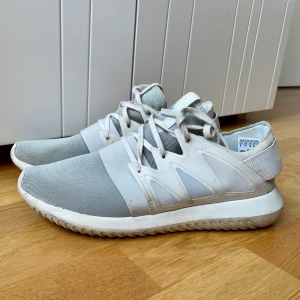 Skor från Adidas - Vita sneakers från Adidas. Knappt använda! Väldigt sköna! Sulorna går nog att tvätta väldigt enkelt, så ser de ut som nya.