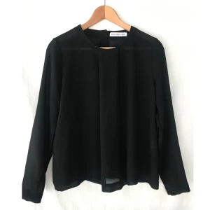 Rodebjer svart blus fint tygvolym St.S - RODEBJER svart blus med fint tygvolym och knappar på ryggen. Storlek S. Nyskick. Material: Polyester 