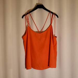 Ett fint, orange/rött linne från Monki. Flera långa korslagda band i ryggen. Storlek M. Frakt tillkommer! 🍁