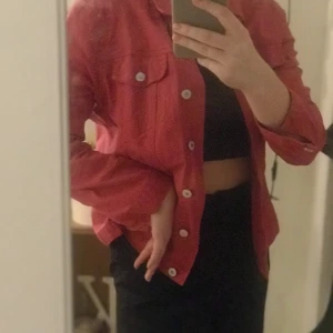 Röd/rosa jacka - Röd rosa jacka med vintage känsla. Är ett tunnare jeanstyg. Använd men det gör lite av vintage stilen ännu bättre. Stl S/M. Frakt tillkommer