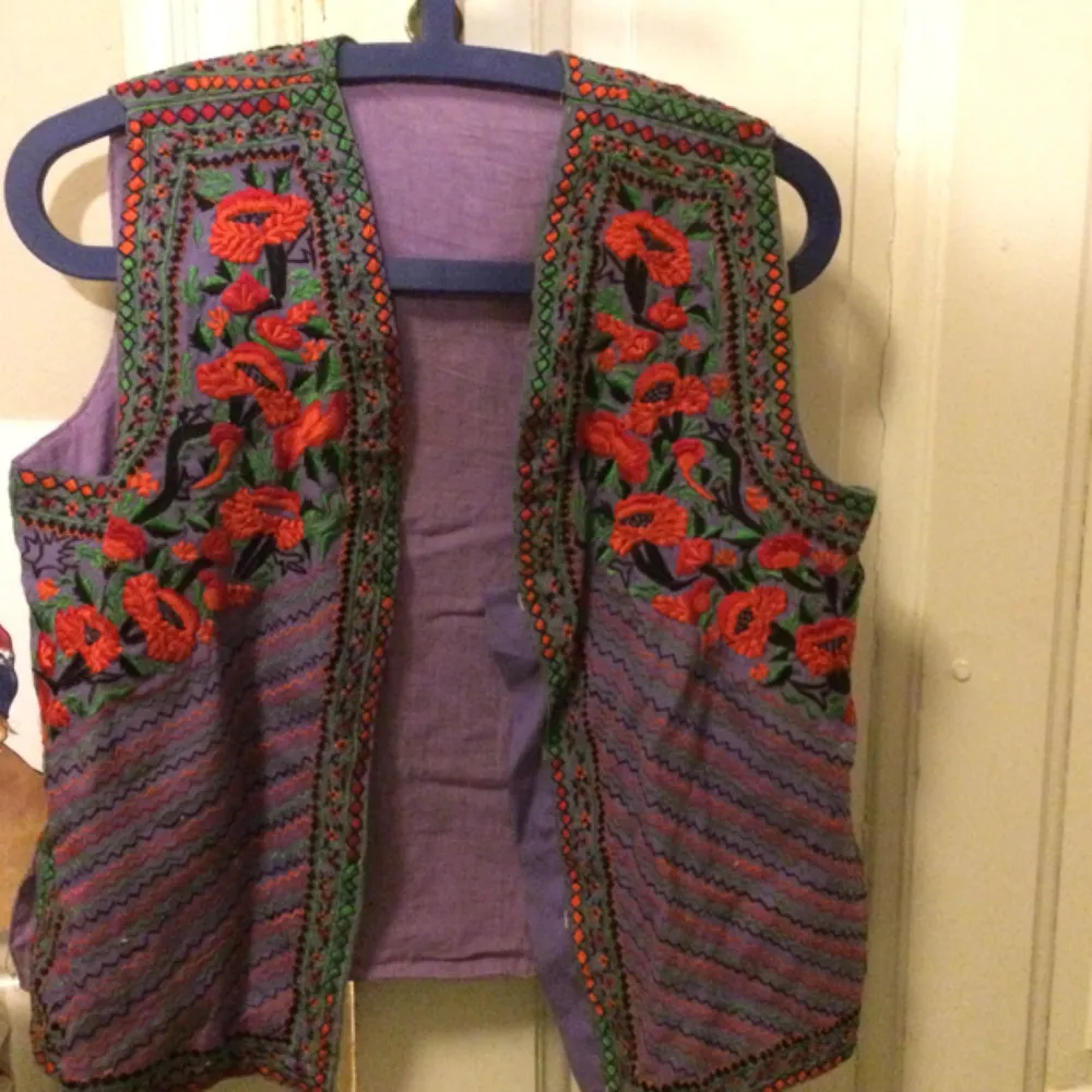 A cool embroidered vest with patterns and flowers . Toppar.