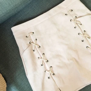  - Beige kjol i fuskmocka, snörning på framsidan och dragkedja bak 🌟 