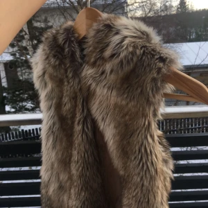  - En super fin faux päls väst! Super bra skick, inga använt väldigt sparsamt. Har en luva och stängs med knappar, skulle inte rekommendera om du har stora  bröst och vill stänga den, dock jr snygg öppen också. Skulle säga att man kan ha den öppen XS-S. 