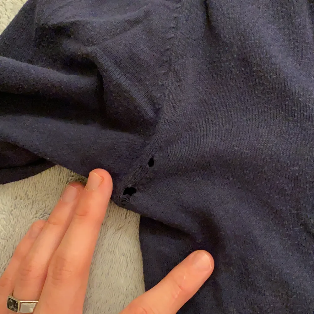 Välanvänd marinblå tröja i storlek S, sitter även bra som M. Har två små hål i sömmen bak vid vänstra armhålan, vet ej om det syns när man har den på sig. Priset är 20kr plus frakt!!. Tröjor & Koftor.