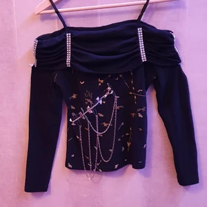 Off-shoulder Tröja med kedja - Off-shoulder tröja med axelband och avtagbar kedja. Axelbanden är reglerbara. Välanvänd men i mycket bra skick. Dragkedjan går inte att öppna. Står ingen storlek men skulle gissa på small. Pris kan diskuteras. Skickas mot fraktkostnad.