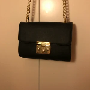 Väska med gulddetaljer  - Jättefin svart väska med guldiga detaljer och två små fack på insidan. Köparen står för frakten, kan mötas upp i Stockholm💕