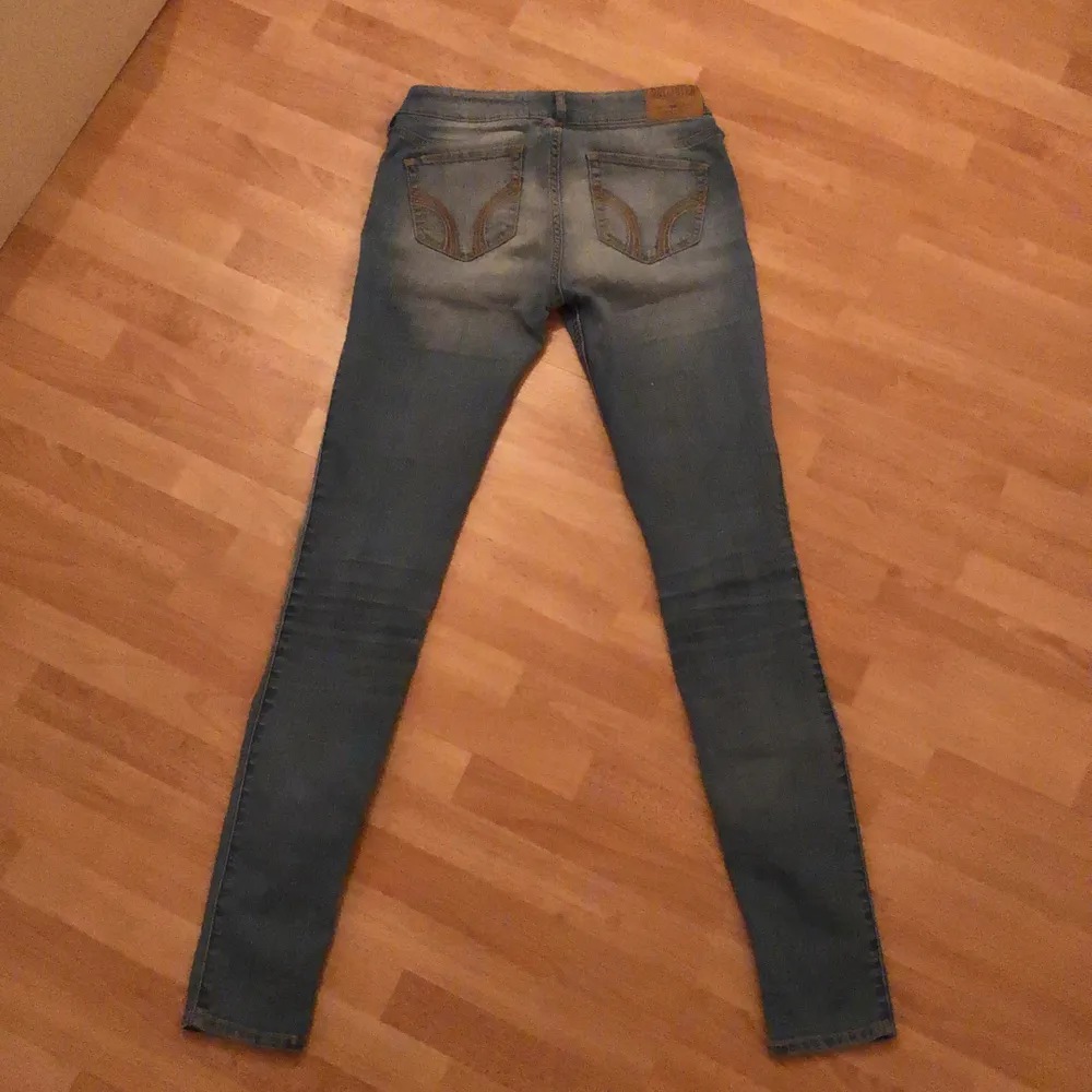 Tajta, lågmidjade, blåa jeans från hollister. Slitningar på båda benen. . Jeans & Byxor.