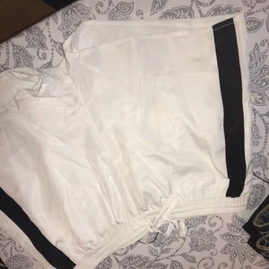  - Vita silkesshorts med svart rand på sidorna. Fraktar endast, frakt ingår i priset.