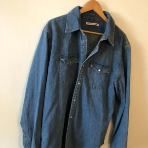  - Snygg jeansskjorta från Levis i bra använt skick. Hämtas i Uppsala eller skickas mot fraktkostnad 