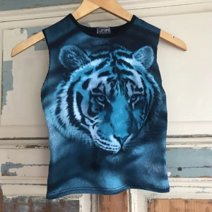  - Så cool 90talig magtröja med en turkos tiger. Den har haft armar som har klippts av. Så snygg både till jeans och kjol.