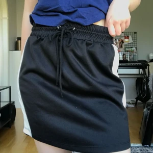  - Svart kjol med vita ränder från Gina tricot. Använd en gång. Möts upp i Stockholm annars tillkommer frakt!