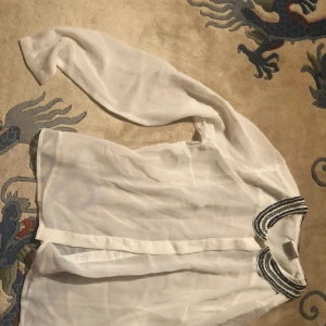  - Vit blus med pärlbroderad krage.  Chiffong tyg 