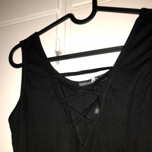  - Svart oanvänd body med snörning från BooHoo. 