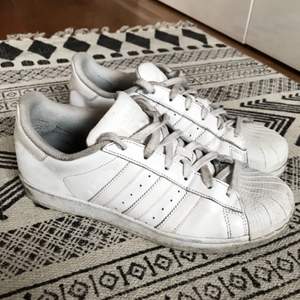 Ett par vita Adidas Superstar sneakers storlek 39, använda ca 15 gånger. En del ytliga fläckar som går att tvätta bort.