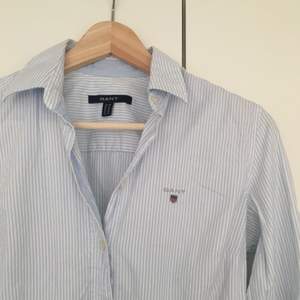 Snygg randig skjorta i ljusblå och vit från Gant. Fint skick, den är knappt använd. Nypris 1000 kr! 